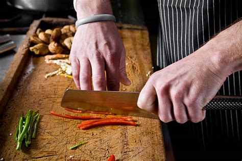 le chef qui coupe des légumes sur une planche en bois-Cuisine Cadeau