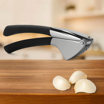 Presse A ail inox ergonomique avec poignées noires, posée sur une planche de cuisine en bois clair