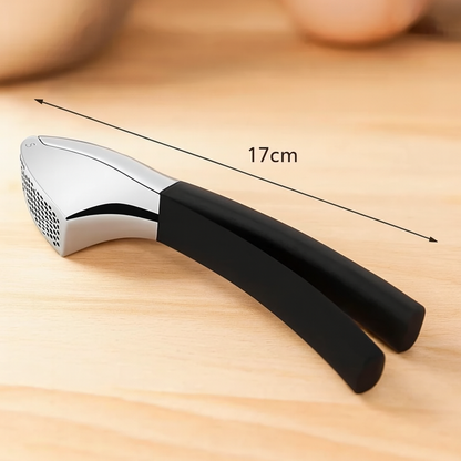 Presse A ail inox de 17 cm avec poignée ergonomique noire, posé sur un plan de cuisine clair.